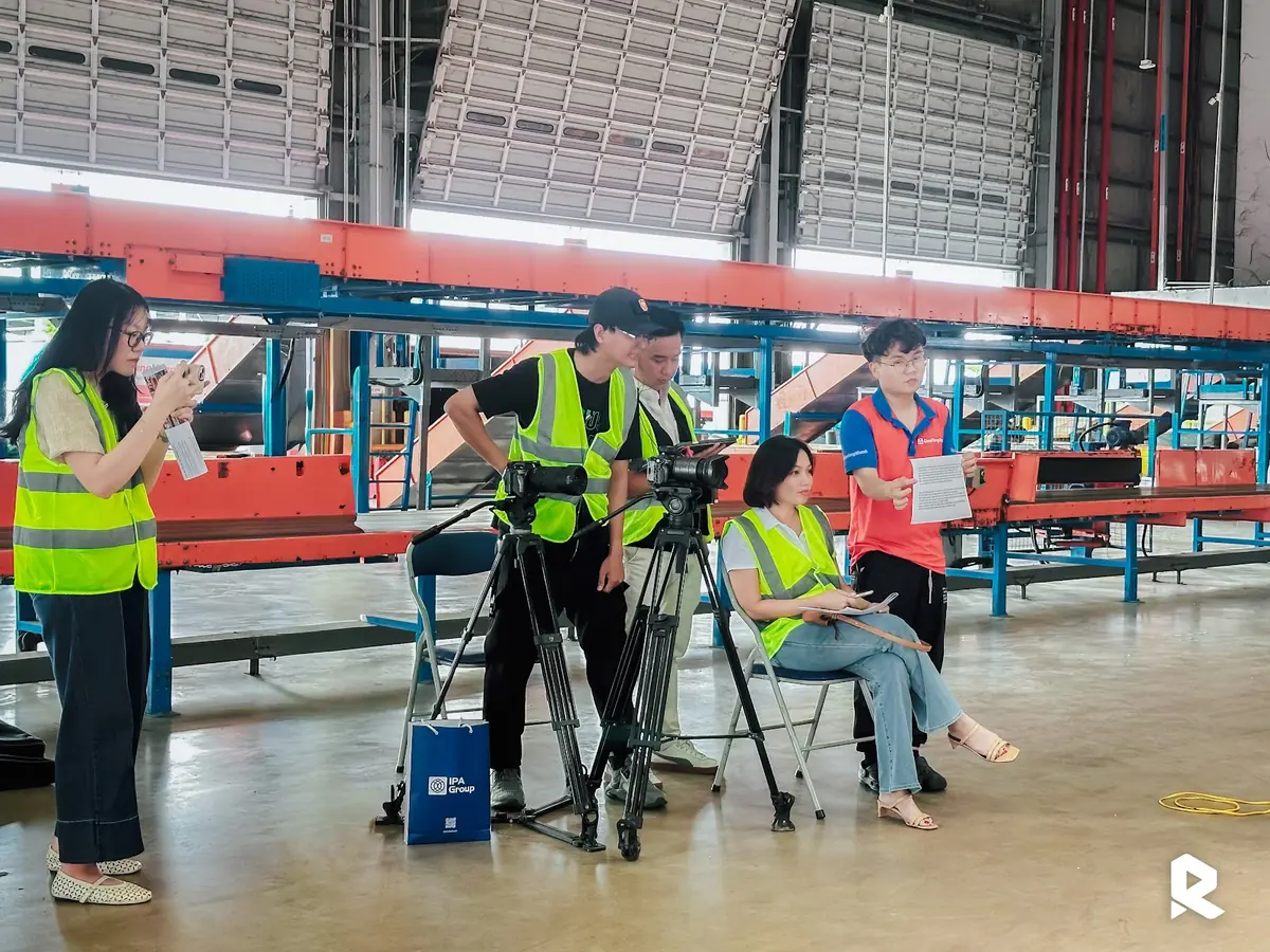 Ekip mặc áo phản quang ghi hình bên trong nhà xưởng tại SLP Park
