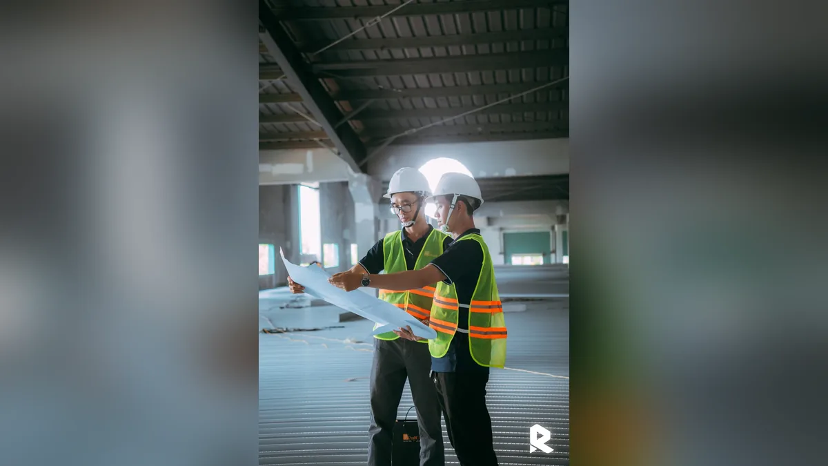 Hai kỹ sư trao đổi trên bản vẽ, cảnh minh họa trong testimonial video ngành xây dựng