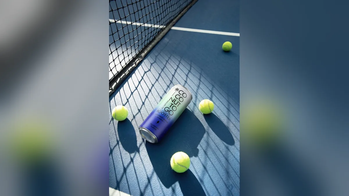 Lon nước dừa Coconuttogo trên sân tennis, cạnh lưới và bóng